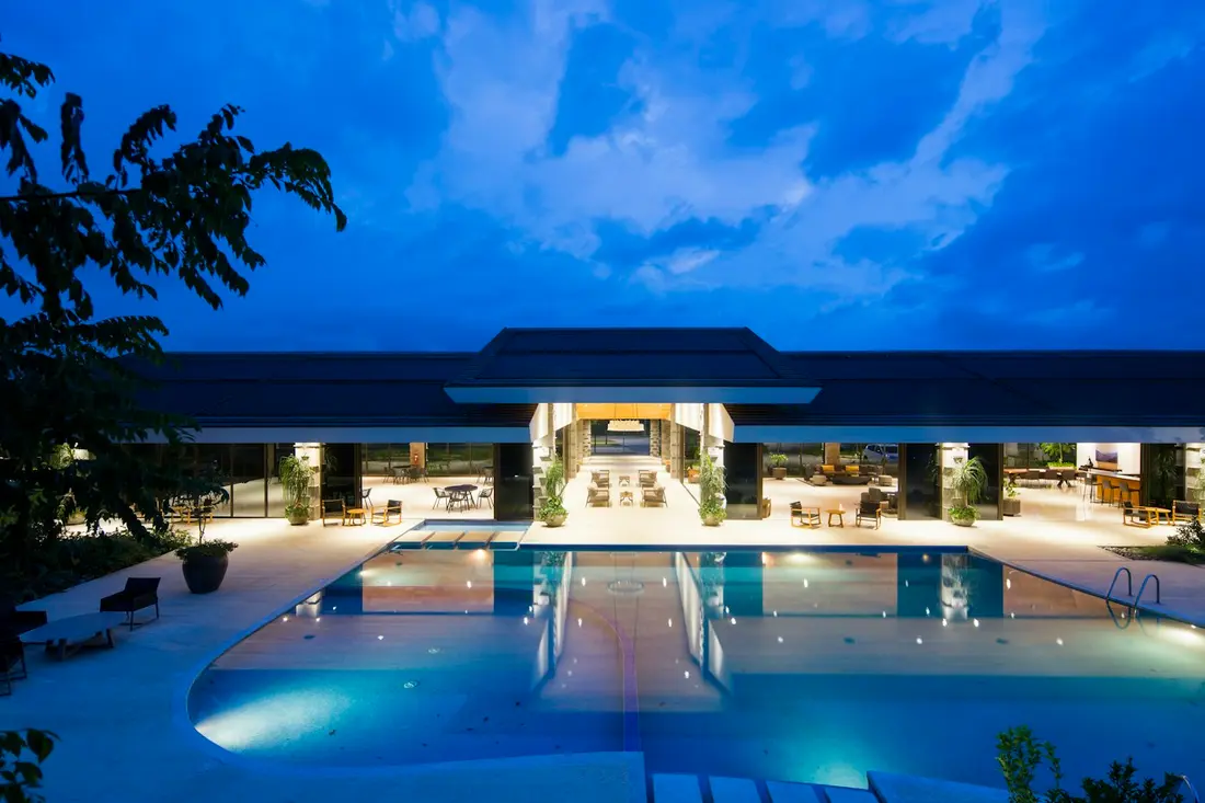 Hotel con alberca iluminada al anochecer
